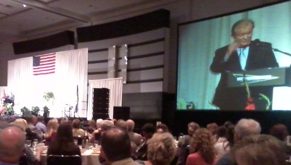 Ambassador Tony Hall gestures on the video screen during the 25th annual Colorado Prayer Luncheon. (Marrton Dormish)
