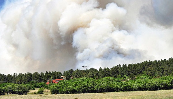 U.S. Army pilots and crewmembers go into thick smoke to release water onto the fire at Black Forest, Colo., on June 12. The fire has since been extinguished, but not before earning the ignominious title of most damaging fire in state history. (Photo by The U.S. Army, Sgt. Jonathan C. Thibault via Wikimedia Commons)